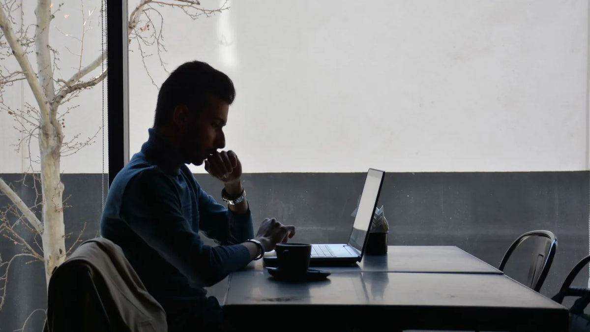 Persona revisando su laptop con gesto pensativo en un escritorio tranquilo