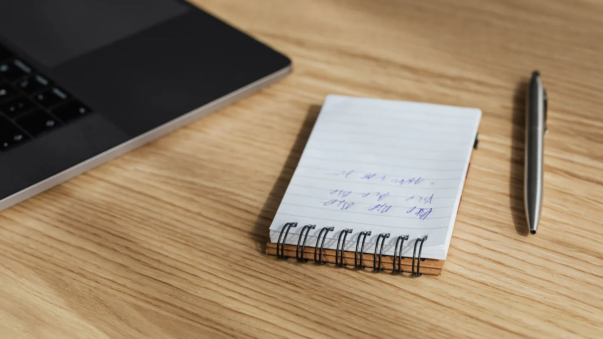Cuaderno con una lista de verificación y un bolígrafo sobre un escritorio ordenado