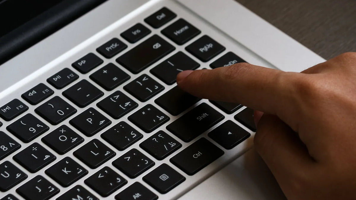 Dedo a punto de pulsar una tecla de una laptop