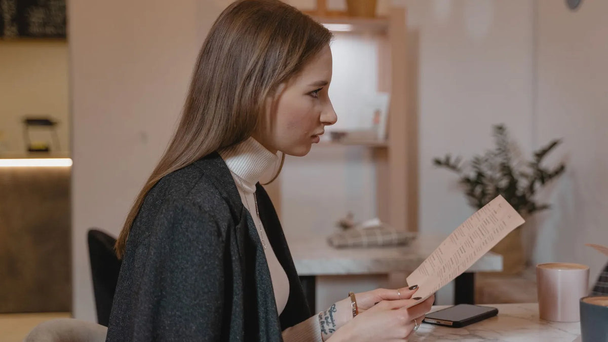 Persona revisando un documento en su escritorio de trabajo