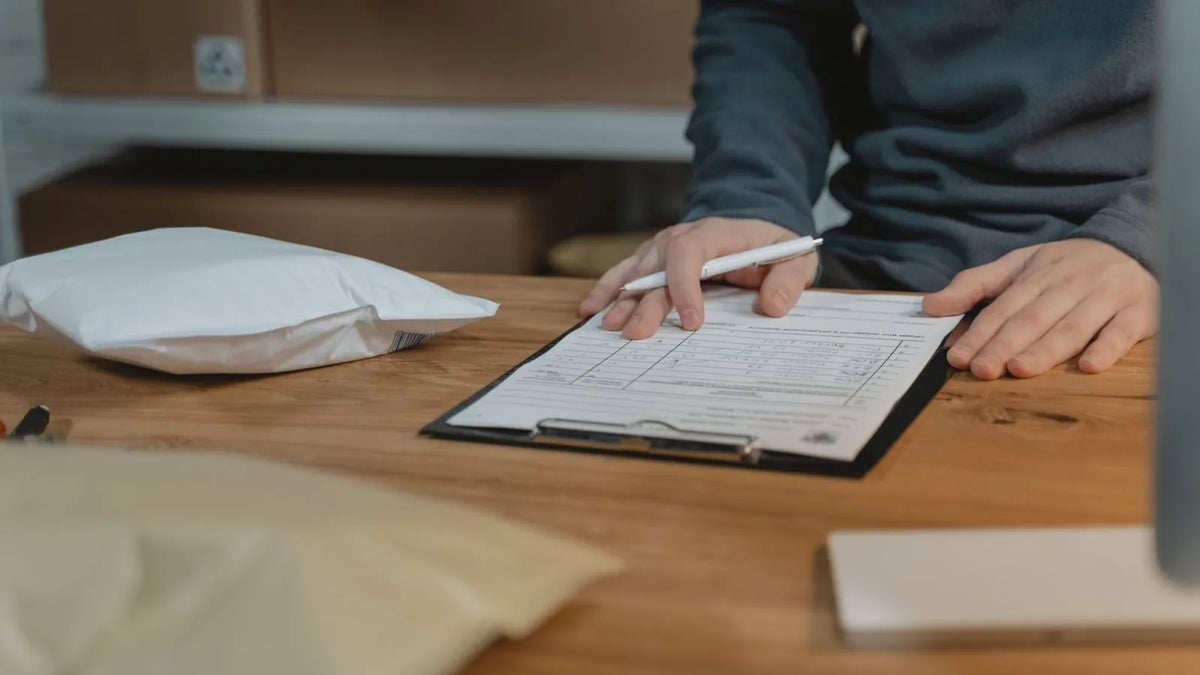Persona revisando una lista impresa sobre una tabla con sujetapapeles