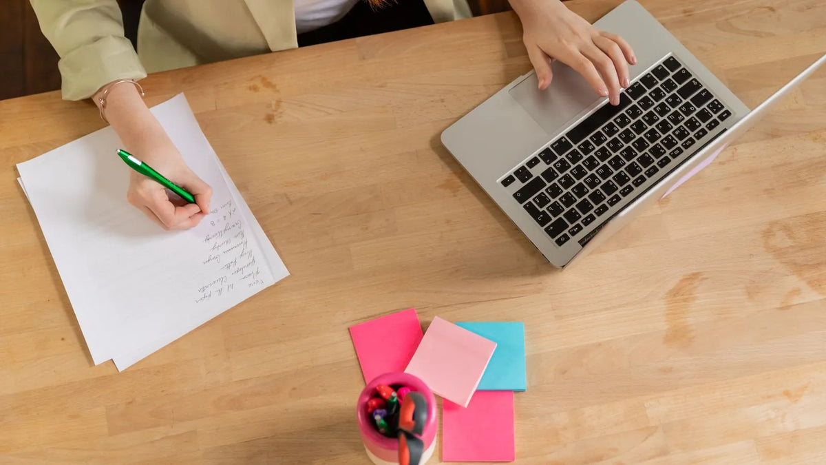 Persona escribiendo frases cortas en notas adhesivas sobre un escritorio
