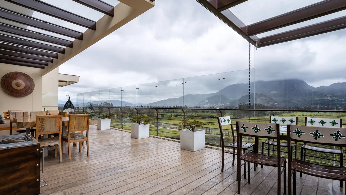 Terraza de un hospedaje con mesas y vista a las montañas