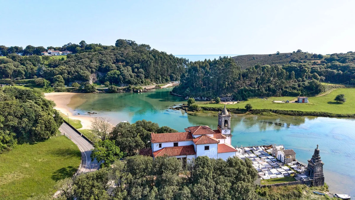 Vista aérea de un pueblo a orillas de un lago entre colinas verdes