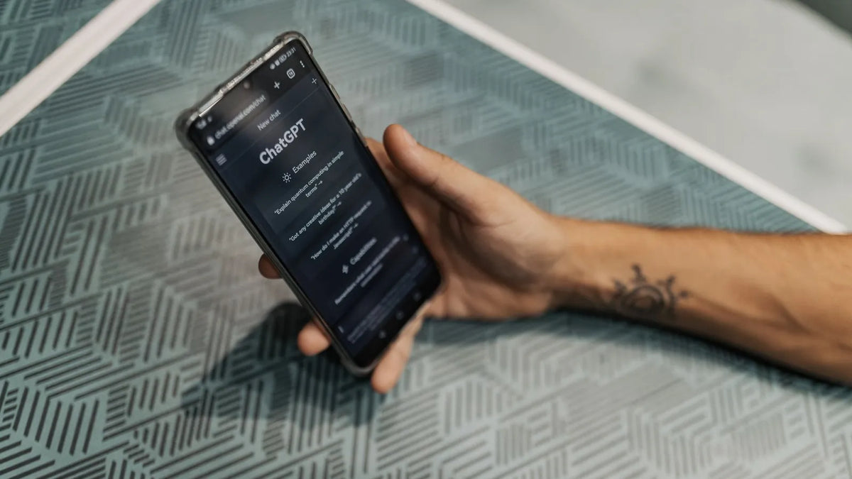 Persona revisando una página web en su teléfono sobre una mesa