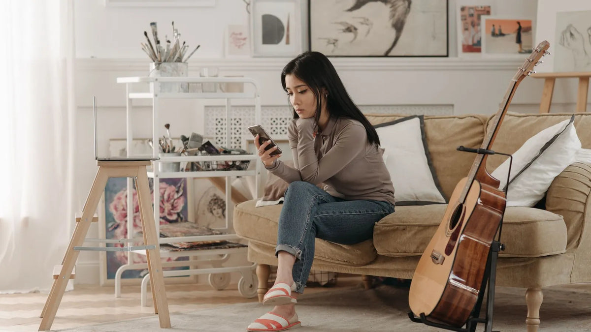 Mujer mirando su teléfono sentada en un sofá