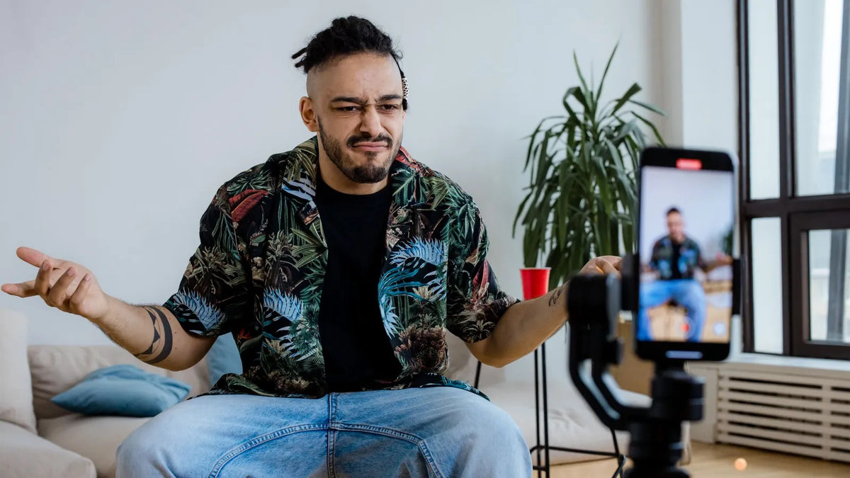 Persona grabando un video hablado con su teléfono sobre un trípode en casa