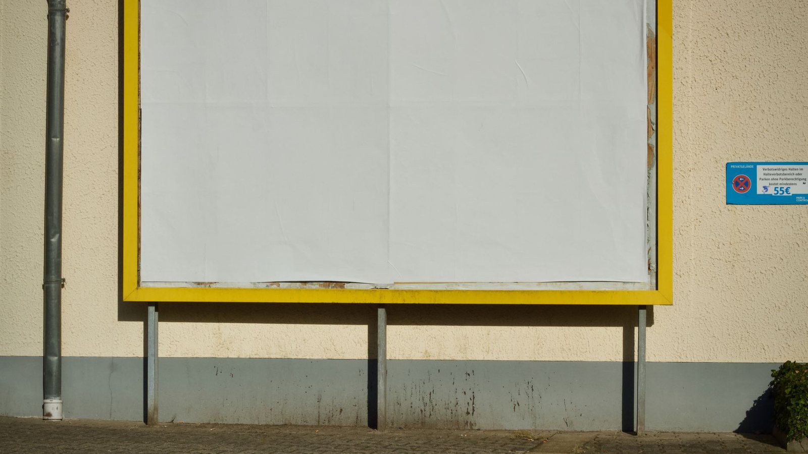 Cartel publicitario vacío con marco amarillo en una calle
