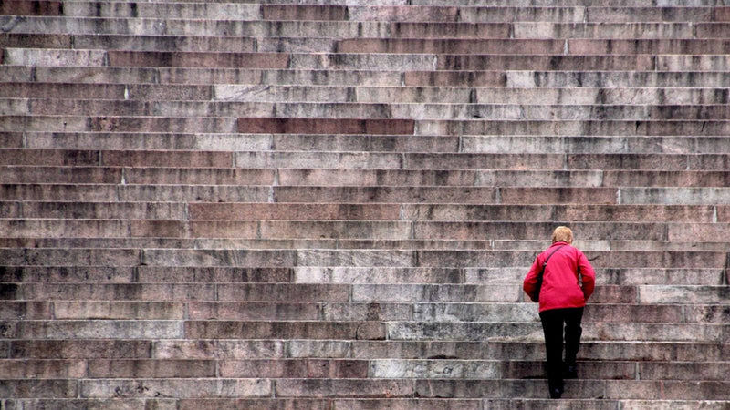 Persona subiendo una gran escalinata de piedra