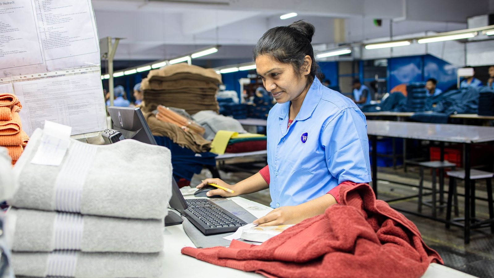 Trabajadora revisando la calidad de toallas en un taller